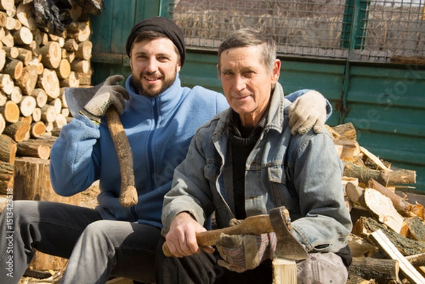 Fototapeta Two men lumberjack sitting resting after hard work.