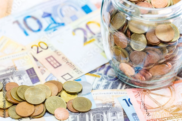 Obraz Coins in a glass jar on the background of other money. Belarus money