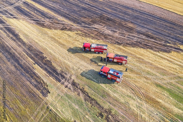 Fototapeta Three rescue vehicles arrived on an urgent call to extinguish a fire in a grain field