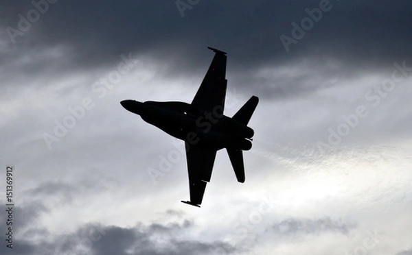 Fototapeta Sylwetka samolotu F18 Hornet Fighter w locie. Chmury w tle.