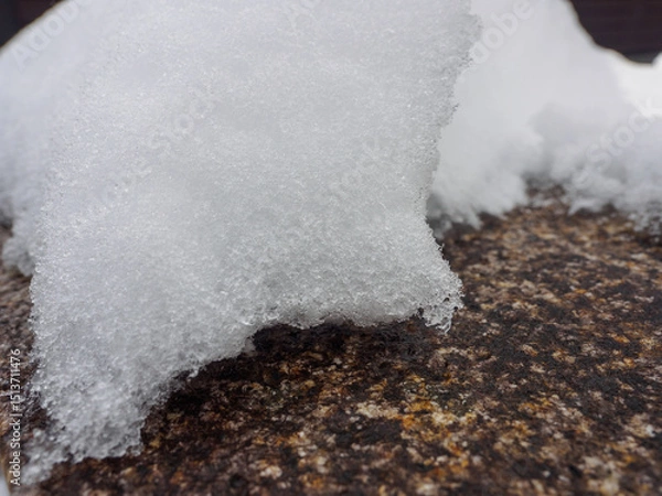 Obraz Close-up of fresh snow resting on a textured rock surface, capturing the intricate detail of icy crystals. Perfect natural winter texture for backgrounds or seasonal designs.