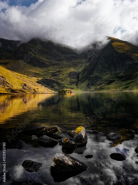 Fototapeta Lough Callee showcases stunning natural beauty with calm waters reflecting dramatic mountains. The landscape captures the essence of Ireland's scenic tranquility under a cloudy sky.