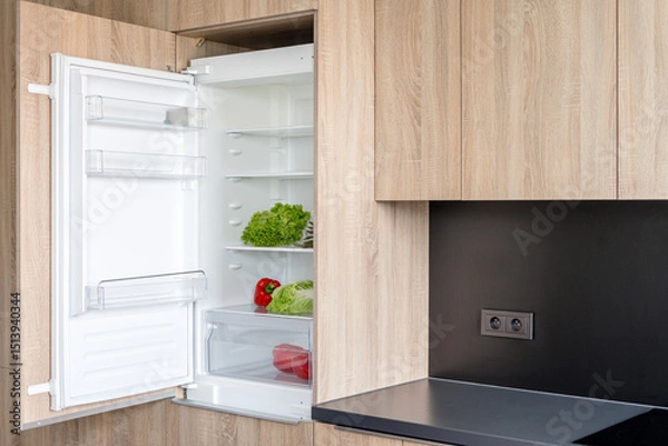 Obraz Open fridge in a modern kitchen displaying fresh food and organized storage