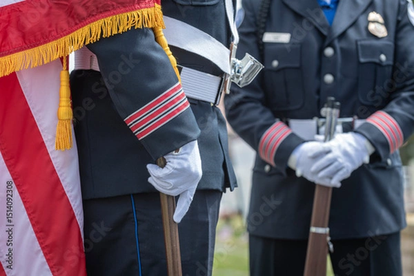 Fototapeta Person wearing a formal uniform with a white belt and gloves, holding a pole.