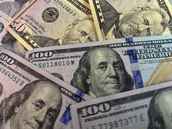 Fototapeta Scattered US dollar bills on a white background. Chaotic money spread representing finance, wealth, risk, cash flow or economic concepts
