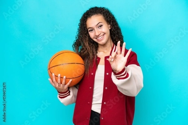Fototapeta Arab basketball player woman isolated on blue background happy and counting three with fingers