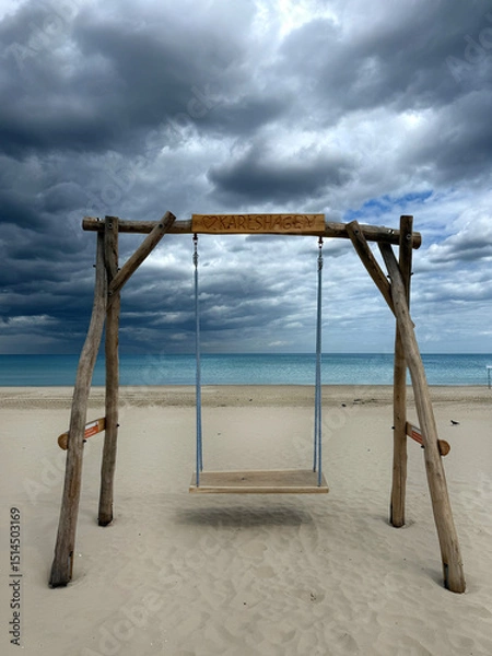 Fototapeta beautiful empty wooden swing on the beach in stormy weather in fall season