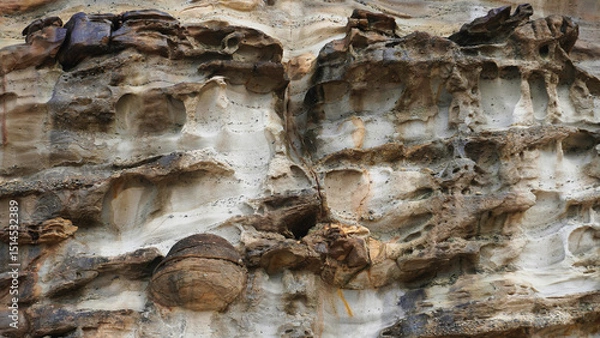 Fototapeta Colorful rock formations showcase the intricate patterns and textures of nature in the coastal landscape during midday light