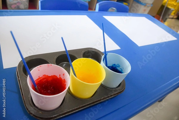 Obraz Set of different cute toys in children's playground. Preschool building exterior with playground and toys on a sunny day