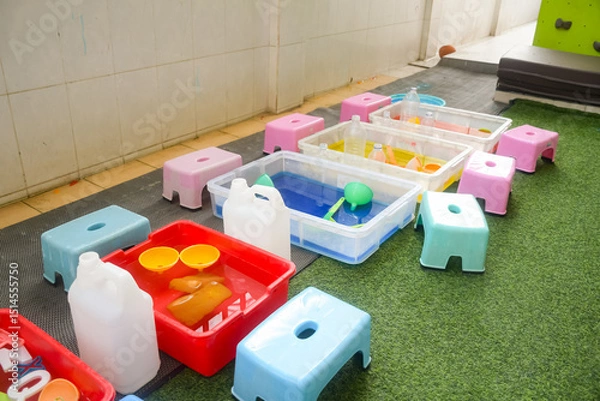 Obraz Set of different cute toys in children's playground. Preschool building exterior with playground and toys on a sunny day