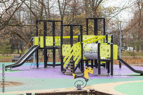 Fototapeta Bright playground in the park. Playground with slides and swings for children.