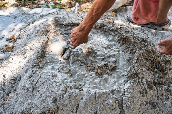 Fototapeta Manual concrete mixing with sand, cement and water, using shovel and trowel on outdoors