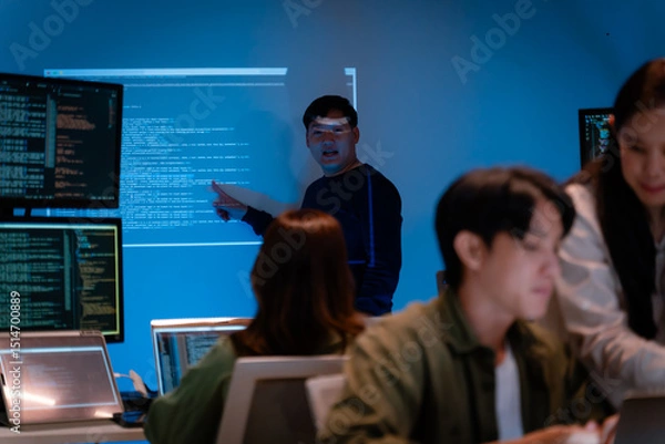 Fototapeta Asian software engineer or programmer team working late in development office,problem solving or algorithm of ai assistant helping for work.software developer,digital technology security concept
