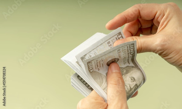 Fototapeta Hands counting US dollar bills, symbolizing finance, payment, banking, and economic transactions