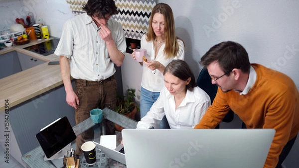 Fototapeta Young specialists in the field of marketing and modern technologies crowded around the head's desk. Business office. Team building