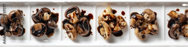 Obraz Sliced mushrooms in dark sauce, arranged on a white platter
