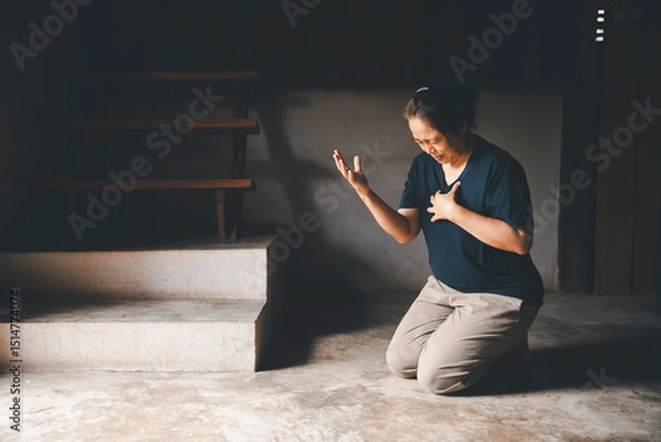 Obraz Female kneeling down praying for worship God at home. Christians pray to jesus christ for calmness. people got to quiet place and worship. Christians humble and submit to God. Banner with copy space.