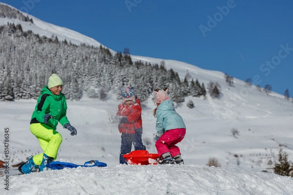 Obraz Happy girl and boys have fun snowball fighting on mountain slope