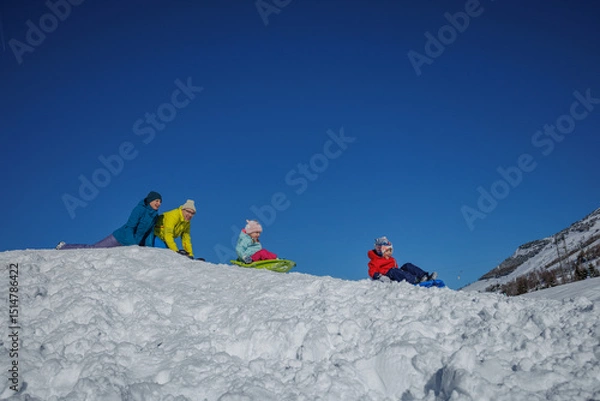 Obraz Family enjoys a sunny day sledding on snowy hills