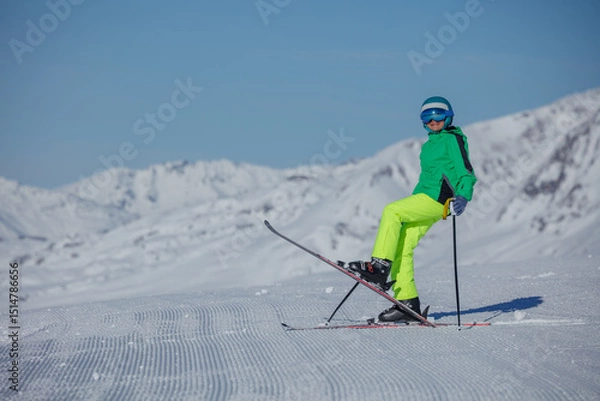 Obraz Skier wear green jacket stand in funny pose on fresh ski slope