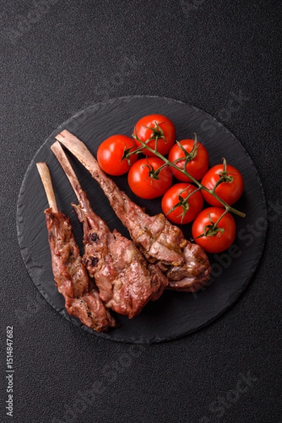 Obraz Juicy meat on the bone or rack of lamb. Grilled veal with salt, spices and herbs