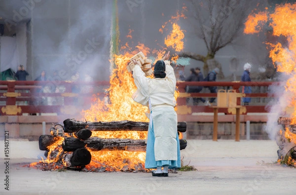 Obraz Shinto priest offering wooden sticks to  holy fire in Setsubun Festival at Heian Jingu shrine, Kyoto, Japan