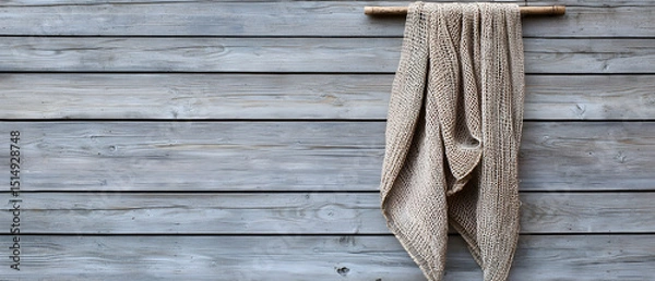 Fototapeta Beige Patterned Blanket Hanging On Gray Wooden Wall