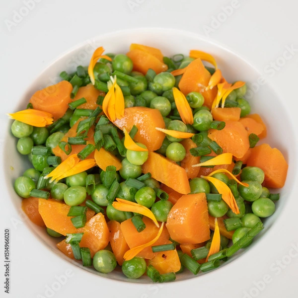 Obraz Fresh garden peas and carrots are cooked with salted butter, then garnished with chives and bright marigold flowers for an appealing and colorful side dish.
