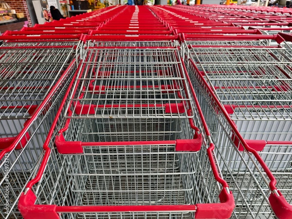 Fototapeta A row of shopping carts is neatly lined up in a straight row