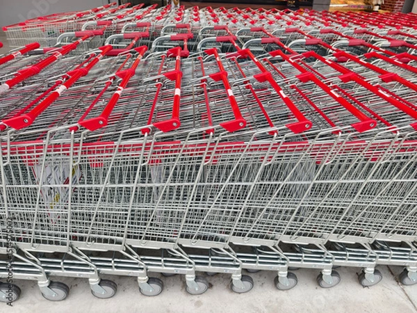 Fototapeta A row of shopping carts is neatly lined up in a straight row