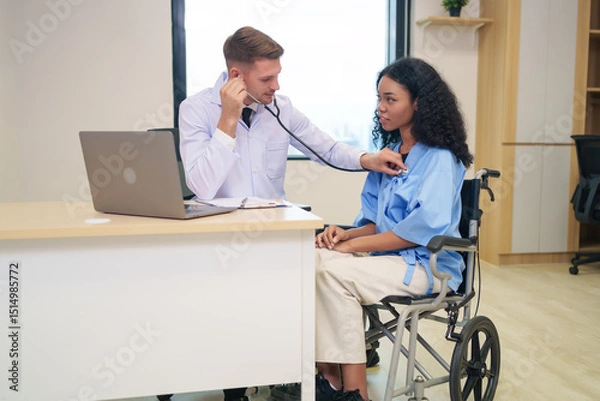 Obraz caucasian doctor in white gown using stethoscope to listen heart beat an afro hair woman client in examine room at hospital