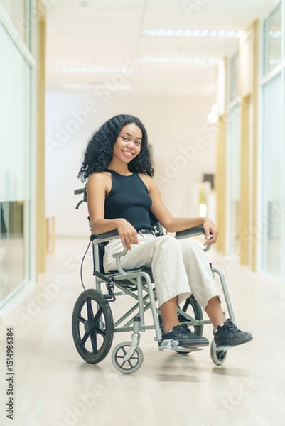 Obraz portrait african woman afro client sitting on wheelchair at corridor,getting service at hospital