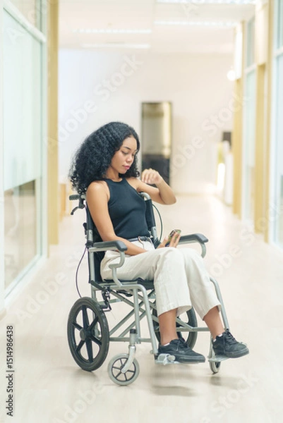 Obraz portrait african woman afro client sitting on wheelchair at corridor,getting service at hospital
