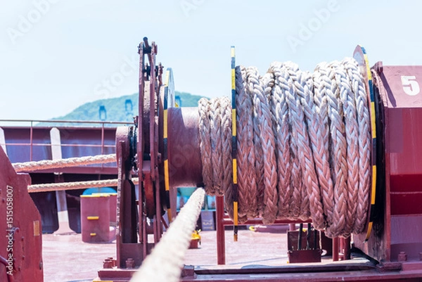 Fototapeta Close-up of mooring rope on a unfocused large mooring winch on the bow of a cargo ship.
