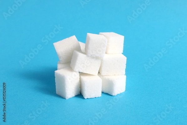 Fototapeta There are a lot of sugar cubes on a blue background.