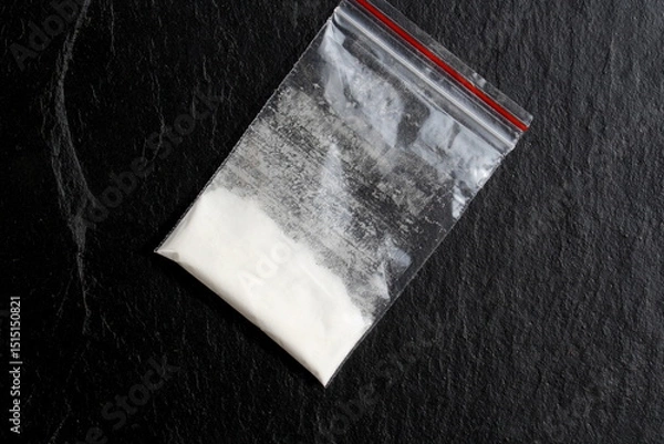 Fototapeta There is a bag of drugs on a black background.