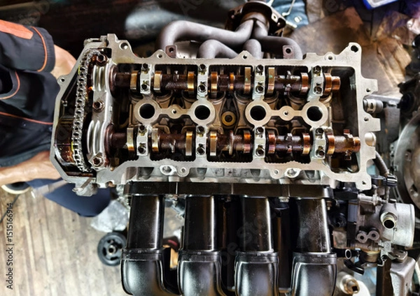 Fototapeta A car engine is being worked on inside a garage workshop