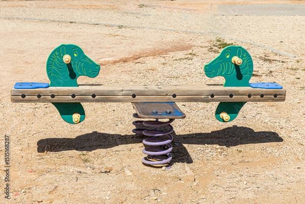 Fototapeta A Swing with green sea horses on a children's playground in the courtyard in summer