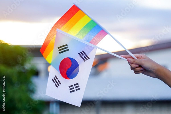 Fototapeta Hand holding rainbow flag and Korean flag which are decorated in homes to show the pride and identity of LGBT people. Soft and selective focus.