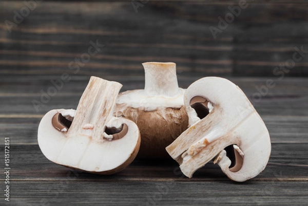 Fototapeta Champignon mushrooms on a wooden background.