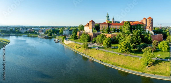 Fototapeta Krakow, Poland. Wide aerial panorama with Polish state owned royal Wawel castle and Gothic cathedral. Vistula river, parks, boulevards, promenades, walking and biking people. Spring, sunset light