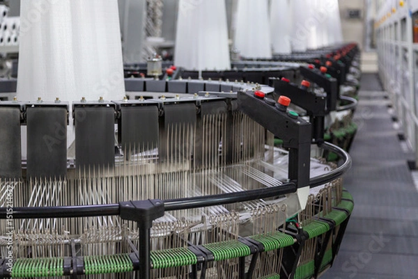 Fototapeta Interior of a factory shop. A series of equipment for weaving polypropylene fabric for construction bags in perspective. Processing of raw materials. Without people.