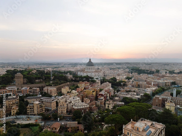 Obraz Peaceful cityscape of Rome at dusk, dominated by St. Peter’s Basilica’s towering dome, glowing against the warm and fading sunset sky. St. Peter’s Basilica silhouetted in evening light, its dome