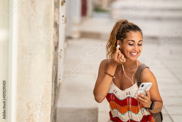 Fototapeta Woman Using A Smartphone And Enjoying Music On A Summer Vacation