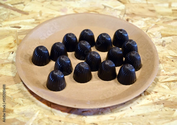 Obraz Chocolates lie on a cardboard plate