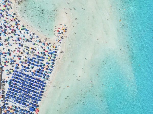 Fototapeta Summer vacation and rest. Beach, people and umbrellas. Top view from drone at the beach and azure sea. View on the coast from drone. Background, wallpaper, postcards.