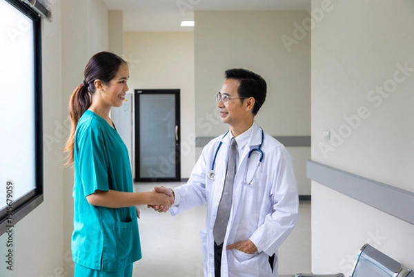 Fototapeta Team of Asian doctor and nurse is handshaking after working on patient medical record for precise care plan with experienced senior physician specialist