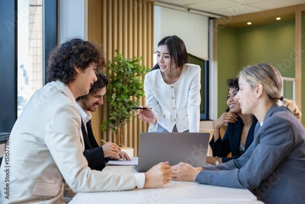 Fototapeta Asian woman sale manager is showing annual report to her colleague in executive meeting for next year plan with market share increase for global business and investment