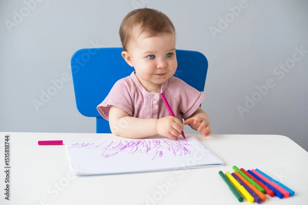 Obraz little girl draws with colored markers. Toddler development
