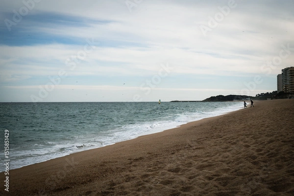 Fototapeta Footsteps on the sand in the shore of a beach with quiet waters in Costa Brava